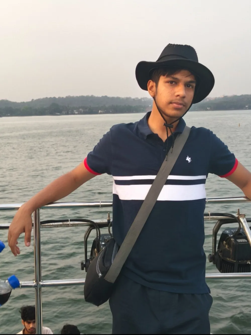 Hardik leaning on the rail of a boat